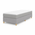 Cama individual tapizada en tela gris con patas de madera